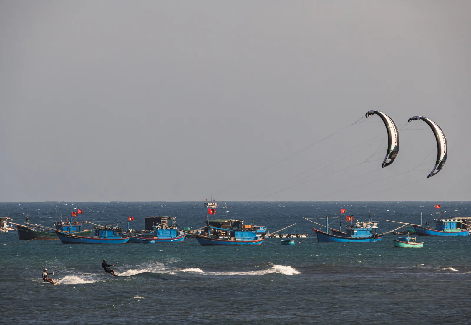 Kitesurfing past fishing boats in Vietnam