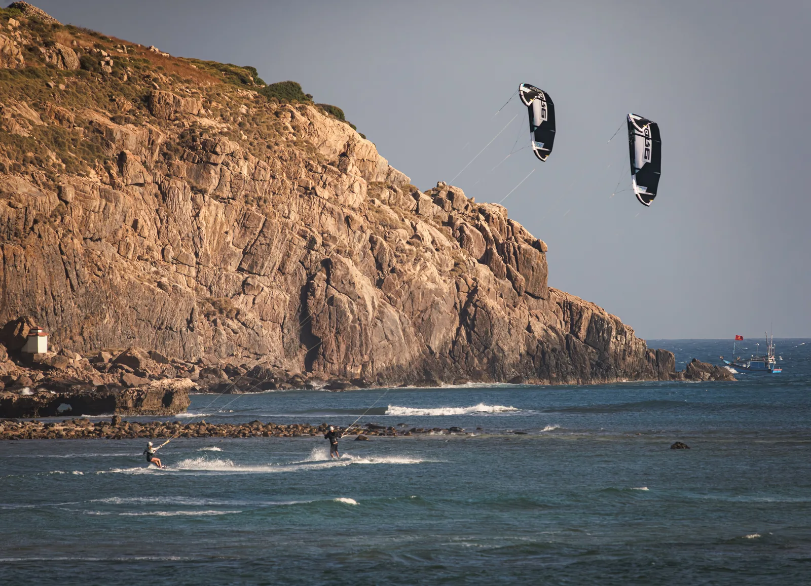 Kitesurfers riding along the rocky coast of Vietnam