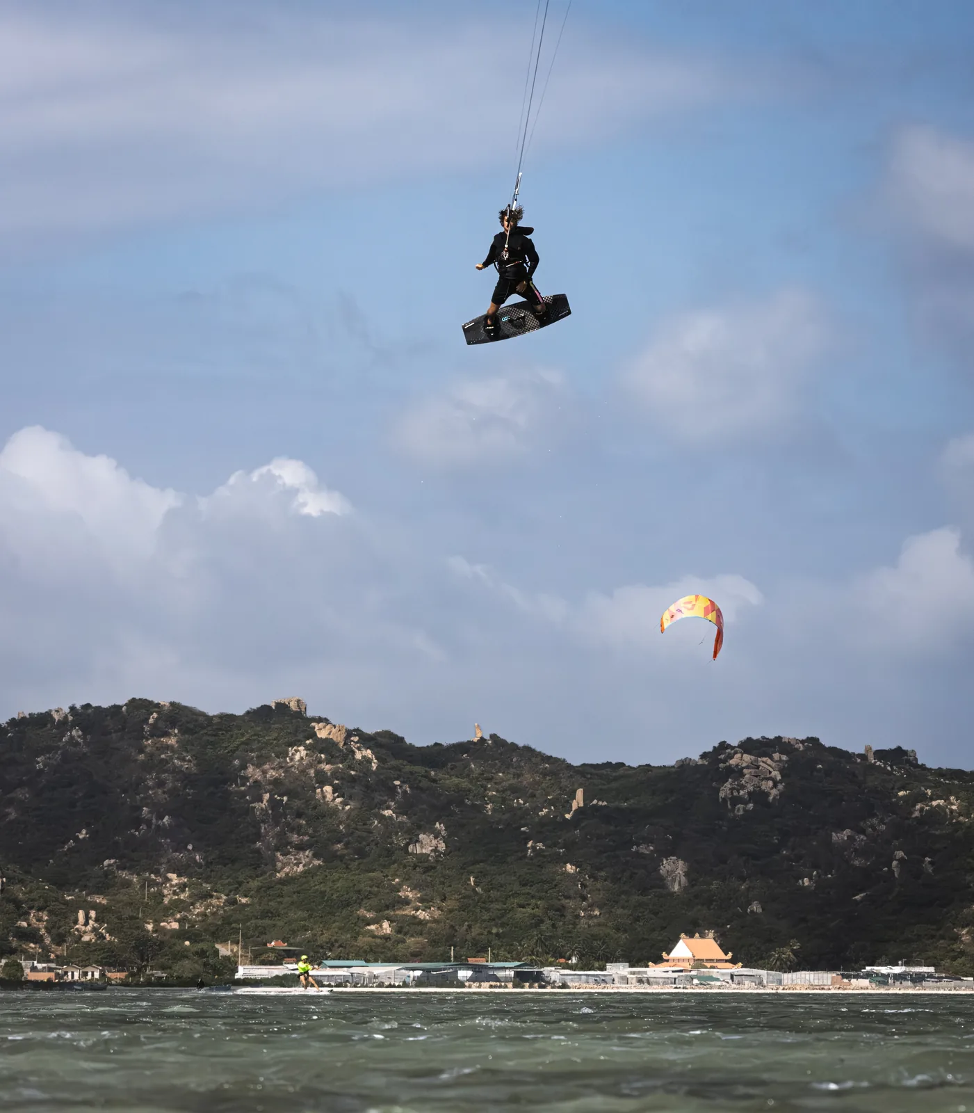 Wojciech Stopa performing a high kitesurfing jump in Vietnam